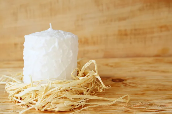 White candle with a beam of hay — Stock Photo, Image