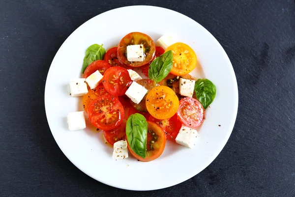 Tomaten met feta in salade top weergave — Stockfoto