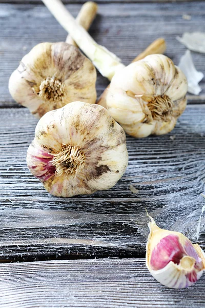 Drei große Knoblauchknollen auf den Brettern — Stockfoto