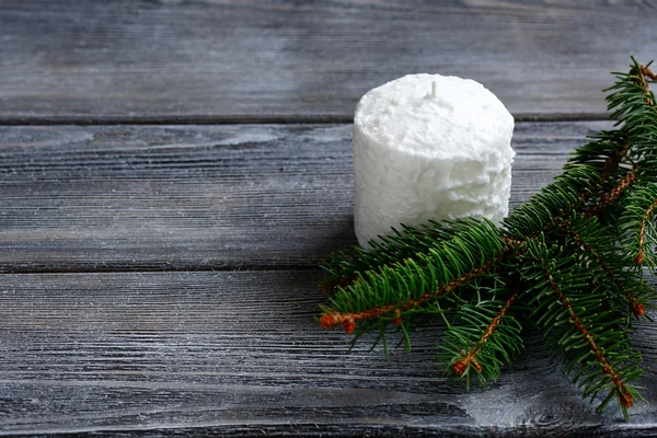 Bougie blanche et branches de sapin sur les planches — Photo