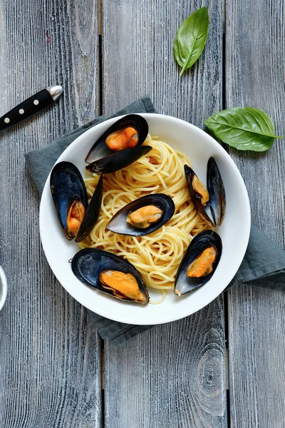 Pasta gegarneerd met mosselen en basilicum — Stockfoto