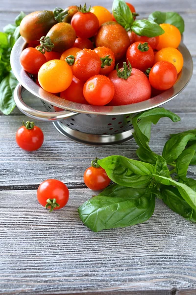 Tomatoes and basil in a steel colander — Stock Photo, Image