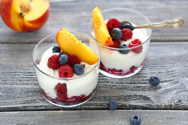 Yogurt with peach slices raspberries and blueberries — Stock Photo, Image