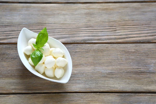 Mozzarella-Kugeln in weißer Schüssel und Basilikum — Stockfoto