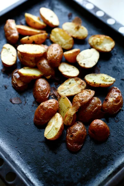 Helften van geroosterde aardappelen op een bakplaat — Stockfoto