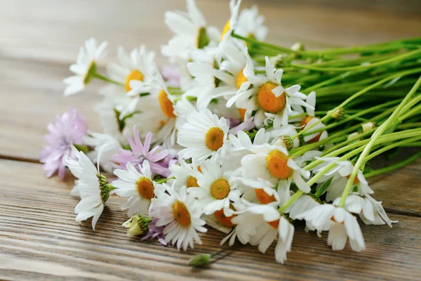 Fleurs fraîches sur un fond en bois — Photo