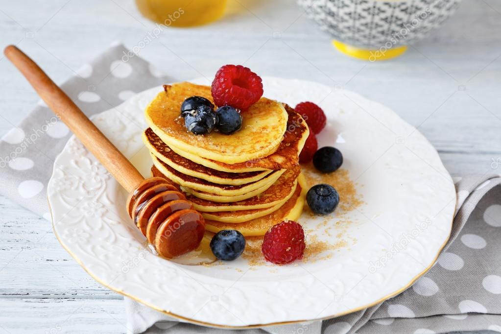 Pancakes with blueberries and honey on a plate