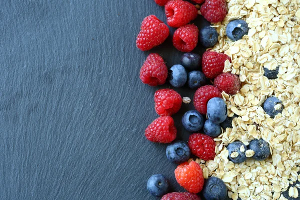 Desayuno saludable y bayas sobre fondo de pizarra — Foto de Stock