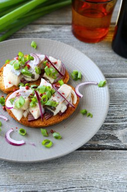 kanepeler ile ringa balığı ve chives bir plaka üzerinde