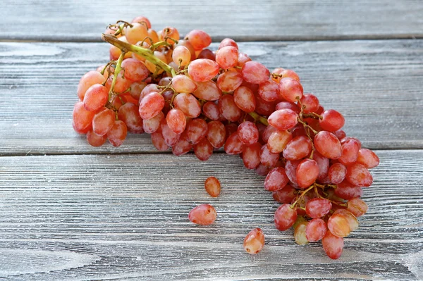 Une grappe de raisin sur une planche de bois — Photo