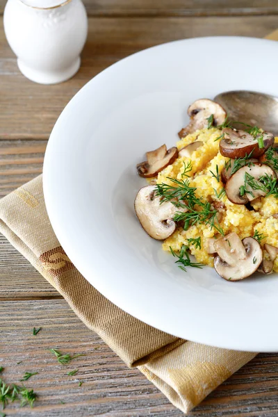 Polenta s žampiony a zelení v bílé desky — Stock fotografie