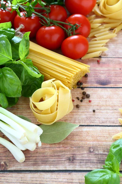 Tomate de espaguete e ervas em umas tábuas de madeira — Fotografia de Stock