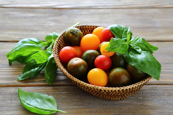 Fresh tomatoes with basil in a wicker basket — Stock Photo, Image