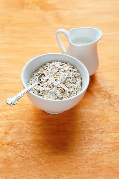 Oatmeal in a bowl on wooden boards — Stock Photo, Image