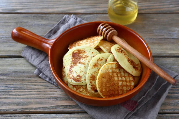 Sweet pancakes with honey on a ceramic pan — Stock Photo, Image