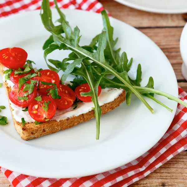 Delicious bruschetta with slices of tomatoes on a white plate — Stock Photo, Image