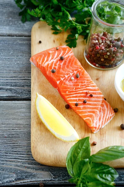 Slice of Salmon with basil and pepper on the board — Stock Photo, Image