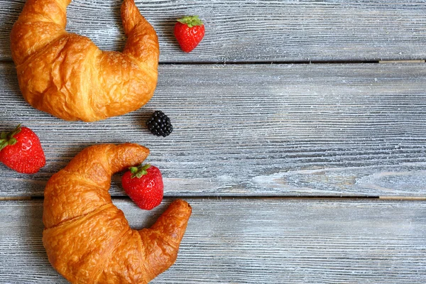 Croissant with berries on wooden boards — Stock Photo, Image