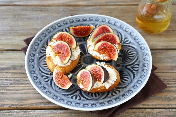 Bruschetta with cheese and figs on a plate — Stock Photo, Image