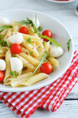 Beyaz tabakta domates ve mozzarella peyniri ile Penne
