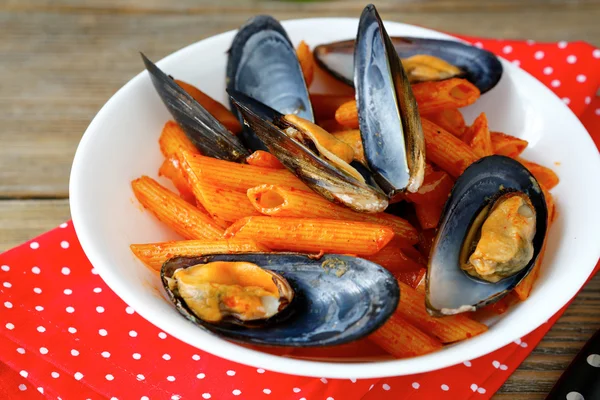 Pasta with mussels in a bowl on napkin — Stock Photo, Image