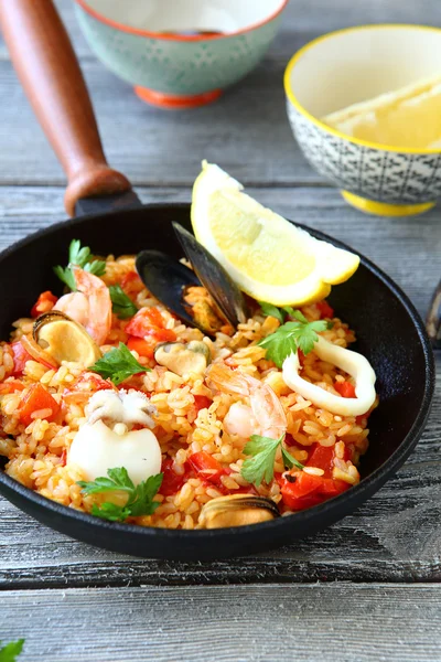 Paella with prawns, mussels and Lemon in a frying pan — Stock Photo, Image