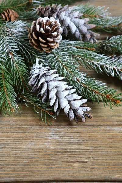 Branche de sapin de Noël recouverte de neige artificielle sur les planches — Photo