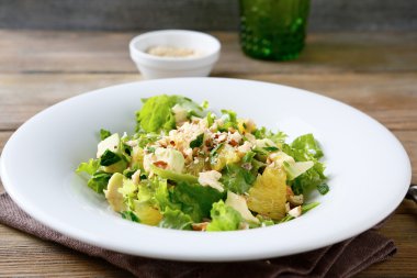 Taze salata avokado, turuncu ve beyaz bir pla ezilmiş fındık