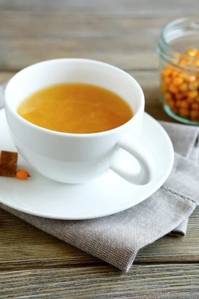 Sanddorntee in einer Tasse auf der linearen Serviette — Stockfoto