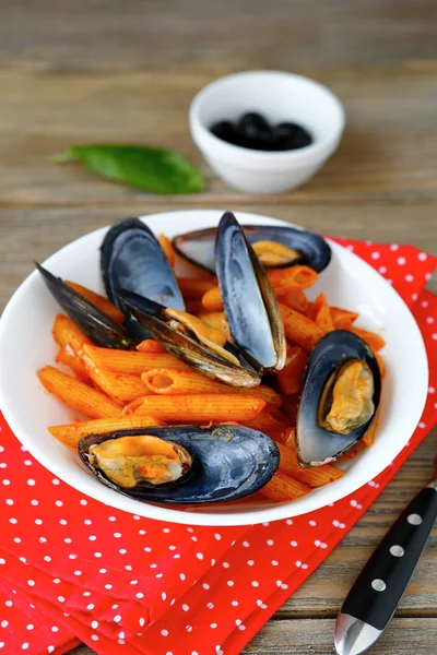 Pasta with mussels in a white plate on napkin — Stock Photo, Image