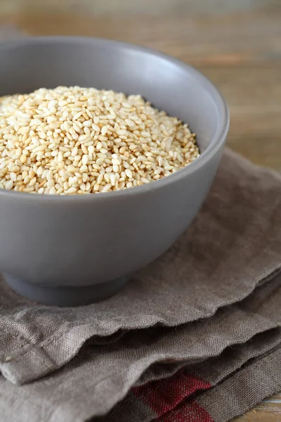 Sesame seeds in a bowl on boards — Stock Photo, Image