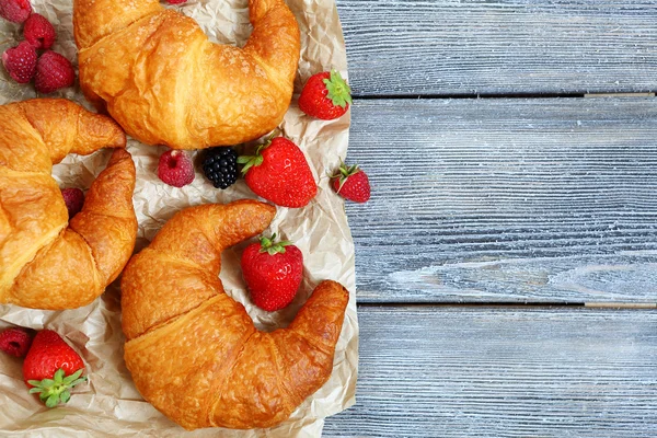 French croissant with berries on paper — Stock Photo, Image