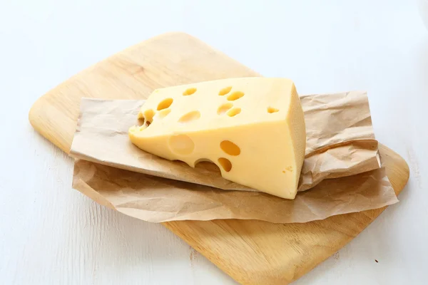Piece of cheese on a board — Stock Photo, Image