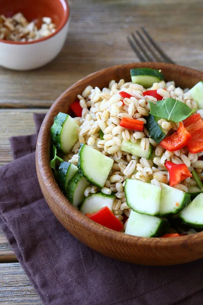 Sabrosa ensalada de cebada perlada con verduras en un tazón de madera — Foto de Stock