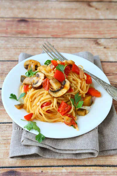 Pasta con champiñones y pimientos en un plato blanco — Foto de Stock