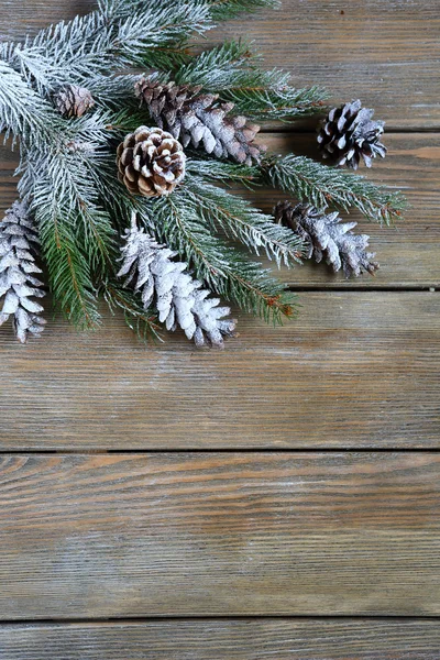 Ramo de abeto de Natal com cones em tábuas de madeira — Fotografia de Stock