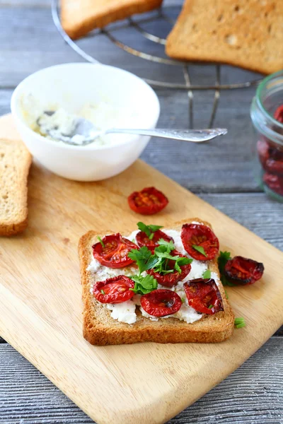 Bruschetta with sun-dried tomatoes on a cutting board — Stock Photo, Image
