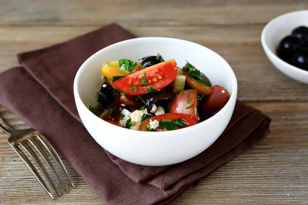 Salad with tomatoes, olives and cheese in a white bowl — Stock Photo, Image