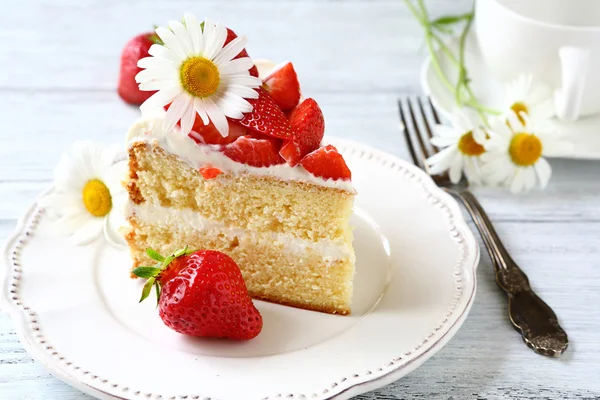 Pièce de délicieux gâteau sur une assiette blanche — Photo