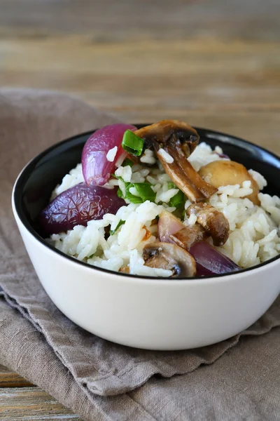 Smakelijke rijst met champignons en uien in een kom — Stockfoto