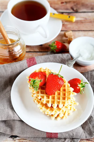 Waffles com morangos e chá preto doce — Fotografia de Stock