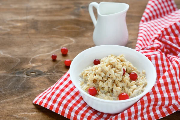 Farina d'avena con bacche e latte sulle tavole — Foto Stock