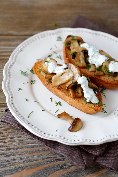 Bruschetta s houbami na bílé plotně — Stock fotografie