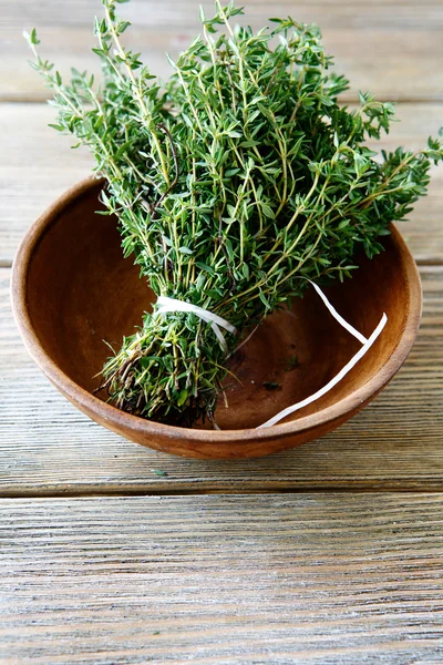 Fresh thyme in a bowl on wooden boards — Stock Photo, Image