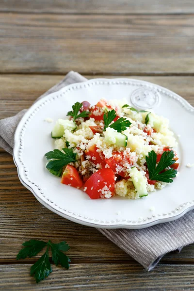 Салат со свежими овощами и кускусом на тарелке — стоковое фото