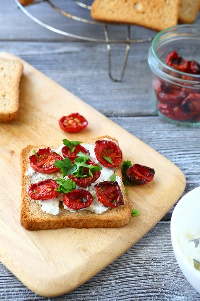 Bruschetta con tomates secados al sol en el tablero — Foto de Stock