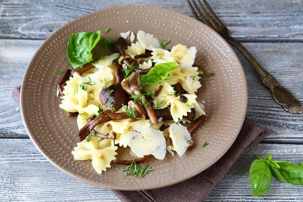 Вкусная паста с грибами и базиликом на тарелке — стоковое фото