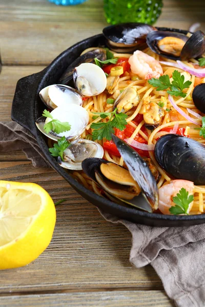 Pasta with mussels, squid and parsley in a frying pan — Stock Photo, Image