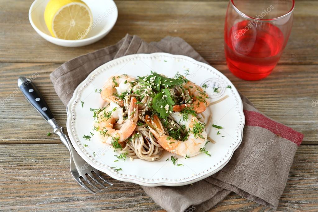 Buckwheat noodles with shrimp and cilantro on a white plate Stock Photo