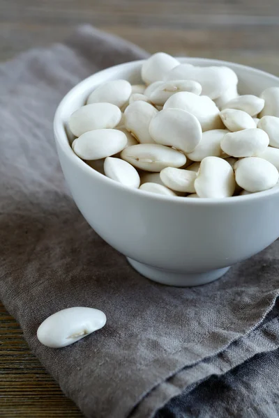 Frijoles blancos en un tazón en una servilleta de lino —  Fotos de Stock